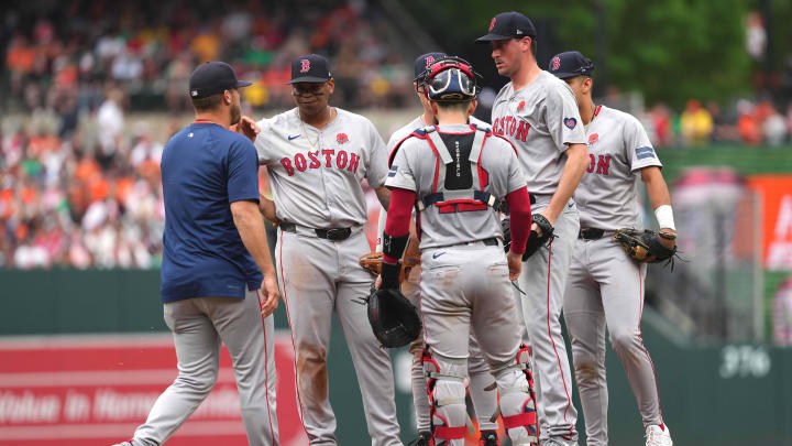 May 27, 2024; Baltimore, Maryland, USA; Boston Red Sox starting pitcher Cooper Criswell (right) awaits a mound visit by pitching coach Andrew Bailey (left) in the fourth inning against the Baltimore Orioles at Oriole Park at Camden Yards. Mandatory Credit: Mitch Stringer-USA TODAY Sports