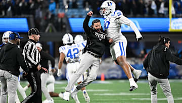 Dec 6, 2025; Charlotte, NC, USA; Duke Blue Devils head coach Manny Diaz reacts with defensive tackle Aaron Hall (99) in the first quarter against the Virginia Cavaliers during the 2025 ACC Championship game at Bank of America Stadium. Mandatory Credit: Bob Donnan-Imagn Images