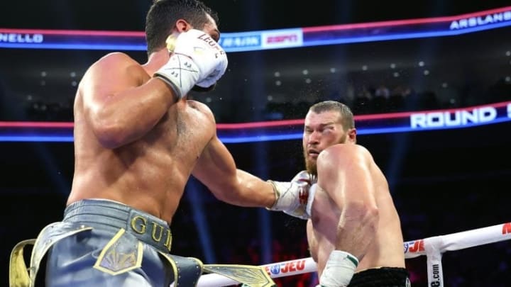 Guido Vianello [left] honors a clear triumph as the swollen eye of Arslanbek Makhmudov [right] causes a stop in the eighth round