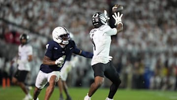 Sep 27, 2025; University Park, Pennsylvania, USA; Oregon Ducks wide receiver Dakorien Moore (1) makes a catch past Penn State Nittany Lions cornerback A.J. Harris (4) during the fourth quarter at Beaver Stadium. Mandatory Credit: James Lang-Imagn Images