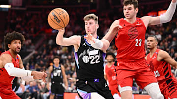 Apr 9, 2025; Salt Lake City, Utah, USA;  Utah Jazz center Kyle Filipowski (22) passes off the ball in front of Portland Trail Blazers center Donovan Clingan (23) in the first half at Delta Center. Mandatory Credit: Jamie Sabau-Imagn Images