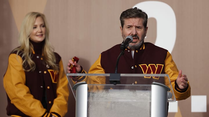 Feb 2, 2022; Landover, MD, USA; Washington Commanders co-owner Dan Snyder speaks as co-owner Tanya Snyder (L) listens during a press conference revealing the Commanders as the new name for the formerly named Washington Football Team at FedEx Field. Mandatory Credit: Geoff Burke-Imagn Images Feb 2, 2022; Landover, MD, USA; Washington Commanders co-owner Dan Snyder speaks as co-owner Tanya Snyder (L) listens during a press conference revealing the Commanders as the new name for the formerly named Washington Football Team at FedEx Field. Mandatory Credit: Geoff Burke-Imagn Images