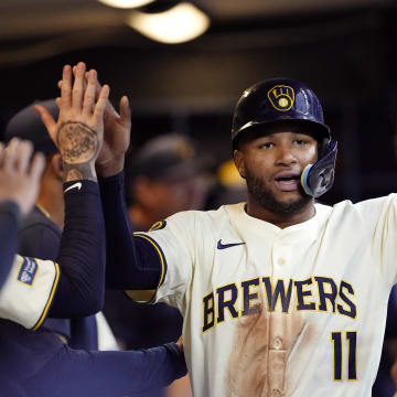 Jul 9, 2024; Milwaukee, Wisconsin, USA;  Milwaukee Brewers right fielder Jackson Chourio (11) celebrates in the dugout after scoring a run during the third inning against the Pittsburgh Pirates at American Family Field.