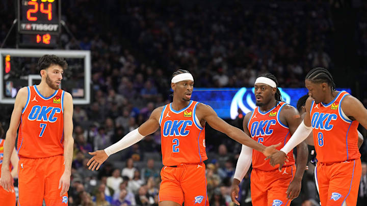 Dec 14, 2023; Sacramento, California, USA; Oklahoma City Thunder guard Shai Gilgeous-Alexander (2) walks to the bench with forwards Chet Holmgren (7) and Jalen Williams (8) and guard Luguentz Dort (second from right) during the fourth quarter against the Sacramento Kings at Golden 1 Center. Mandatory Credit: Darren Yamashita-Imagn Images