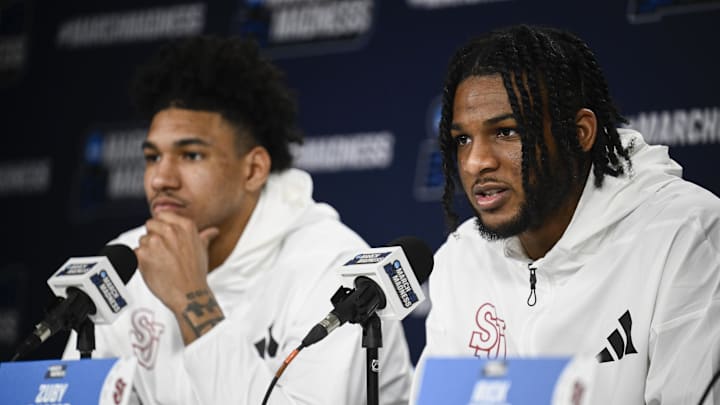 Mar 19, 2026; San Diego, CA, USA; St. John's basketball forward Zuby Ejiofor (24), right, speaks at a press conference as forward Dillon Mitchell (1) looks on ahead of the first round of the men's 2026 NCAA Tournament at Viejas Arena.