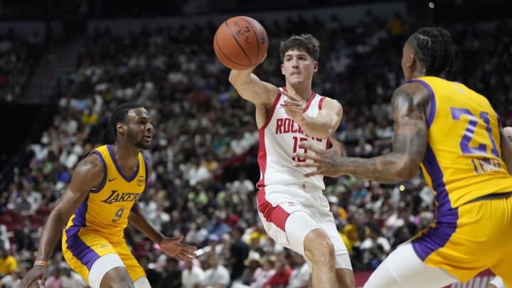 Jul 12, 2024; Las Vegas, NV, USA;  Houston Rockets guard Reed Sheppard (15) passes the ball between Los Angeles Lakers guard Bronny James (9) and forward Maxwell Lewis (21) during the first half at the Thomas & Mack Center. Mandatory Credit: Lucas Peltier-USA TODAY Sports