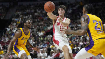 Jul 12, 2024; Las Vegas, NV, USA;  Houston Rockets guard Reed Sheppard (15) passes the ball between Los Angeles Lakers guard Bronny James (9) and forward Maxwell Lewis (21) during the first half at the Thomas & Mack Center. Mandatory Credit: Lucas Peltier-USA TODAY Sports