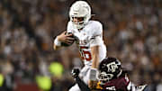 Nov 30, 2024; College Station, Texas, USA; Texas Longhorns quarterback Arch Manning (16) runs the ball as Texas A&M Aggies defensive back Dashawn Fillmore (26) defends during the second quarter at Kyle Field. Mandatory Credit: Maria Lysaker-Imagn Images 