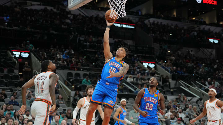 Jan 24, 2024; San Antonio, Texas, USA;  Oklahoma City Thunder forward Keyontae Johnson (18) shoots in front of San Antonio Spurs guard Blake Wesley (14) in the second  half at Frost Bank Center. Mandatory Credit: Daniel Dunn-USA TODAY Sports