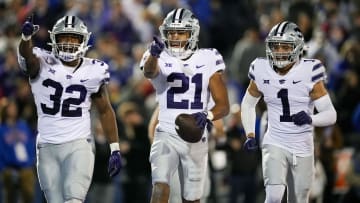 Nov 18, 2023; Lawrence, Kansas, USA; Kansas State Wildcats safety Marques Sigle (21) celebrates with linebacker Desmond Purnell (32) and cornerback Keenan Garber (1) after an interception during the second half against the Kansas Jayhawks at David Booth Kansas Memorial Stadium. Mandatory Credit: Jay Biggerstaff-USA TODAY Sports