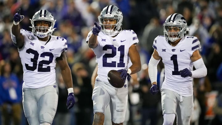 Nov 18, 2023; Lawrence, Kansas, USA; Kansas State Wildcats safety Marques Sigle (21) celebrates with linebacker Desmond Purnell (32) and cornerback Keenan Garber (1) after an interception during the second half against the Kansas Jayhawks at David Booth Kansas Memorial Stadium. Mandatory Credit: Jay Biggerstaff-USA TODAY Sports