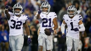 Nov 18, 2023; Lawrence, Kansas, USA; Kansas State Wildcats safety Marques Sigle (21) celebrates with linebacker Desmond Purnell (32) and cornerback Keenan Garber (1) after an interception during the second half against the Kansas Jayhawks at David Booth Kansas Memorial Stadium. Mandatory Credit: Jay Biggerstaff-USA TODAY Sports