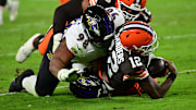 Nov 16, 2025; Cleveland, Ohio, USA; Cleveland Browns quarterback Shedeur Sanders (12) is sacked by Baltimore Ravens cornerback Keyon Martin (38) and defensive tackle Travis Jones (98) during the third quarter at Huntington Bank Field. Mandatory Credit: Ken Blaze-Imagn Images