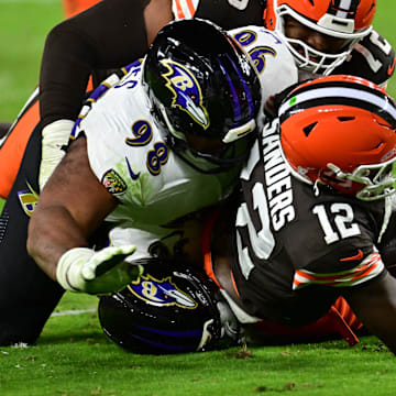 Nov 16, 2025; Cleveland, Ohio, USA; Cleveland Browns quarterback Shedeur Sanders (12) is sacked by Baltimore Ravens cornerback Keyon Martin (38) and defensive tackle Travis Jones (98) during the third quarter at Huntington Bank Field. Mandatory Credit: Ken Blaze-Imagn Images