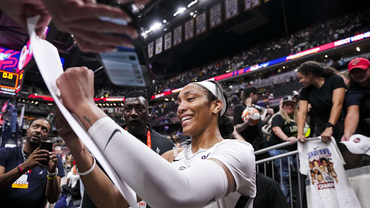 Sep 13, 2024; Indianapolis, Indiana, USA; Las Vegas Aces center A'ja Wilson (22) signs a poster Friday, Sept. 13, 2024, during a game between the Indiana Fever and the Las Vegas Aces on Friday, Sept. 13, 2024, at Gainbridge Fieldhouse in Indianapolis. The Aces defeated the Fever, 78-74.  Mandatory Credit: Grace Smith/USA TODAY Network via Imagn Images