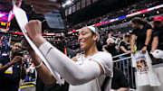 Sep 13, 2024; Indianapolis, Indiana, USA; Las Vegas Aces center A'ja Wilson (22) signs a poster Friday, Sept. 13, 2024, during a game between the Indiana Fever and the Las Vegas Aces on Friday, Sept. 13, 2024, at Gainbridge Fieldhouse in Indianapolis. The Aces defeated the Fever, 78-74.  Mandatory Credit: Grace Smith/USA TODAY Network via Imagn Images