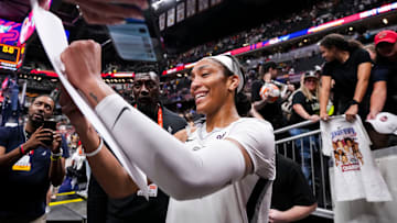 Las Vegas Aces center A'ja Wilson signs a poster during a game between the Indiana Fever and the Las Vegas Aces.