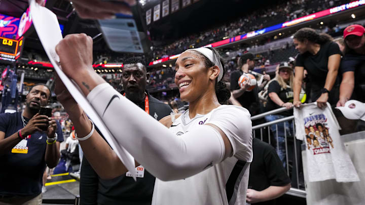 Sep 13, 2024; Indianapolis, Indiana, USA; Las Vegas Aces center A'ja Wilson (22) signs a poster Friday, Sept. 13, 2024, during a game between the Indiana Fever and the Las Vegas Aces on Friday, Sept. 13, 2024, at Gainbridge Fieldhouse in Indianapolis. The Aces defeated the Fever, 78-74. 