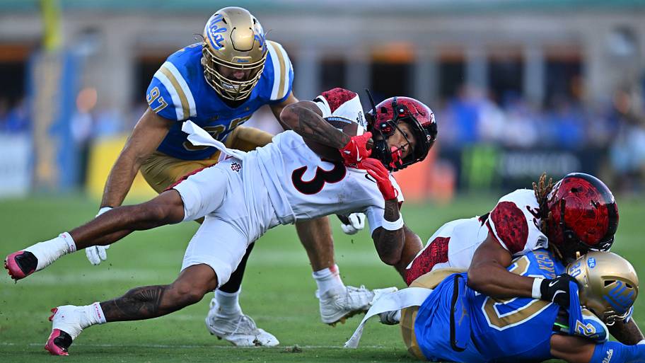 San Diego State WR Nathan Acevedo is taken down by UCLA DL Aiden Gobaira and DB Dante Lovett.