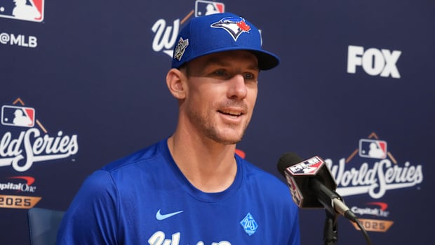Toronto Blue Jays pitcher Chris Bassitt speaks in a press conference in a blue hat and T-shirt