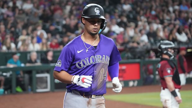 Colorado Rockies shortstop Ezequiel Tovar scores a run against the Arizona Diamondbacks wearing a purple jersey.