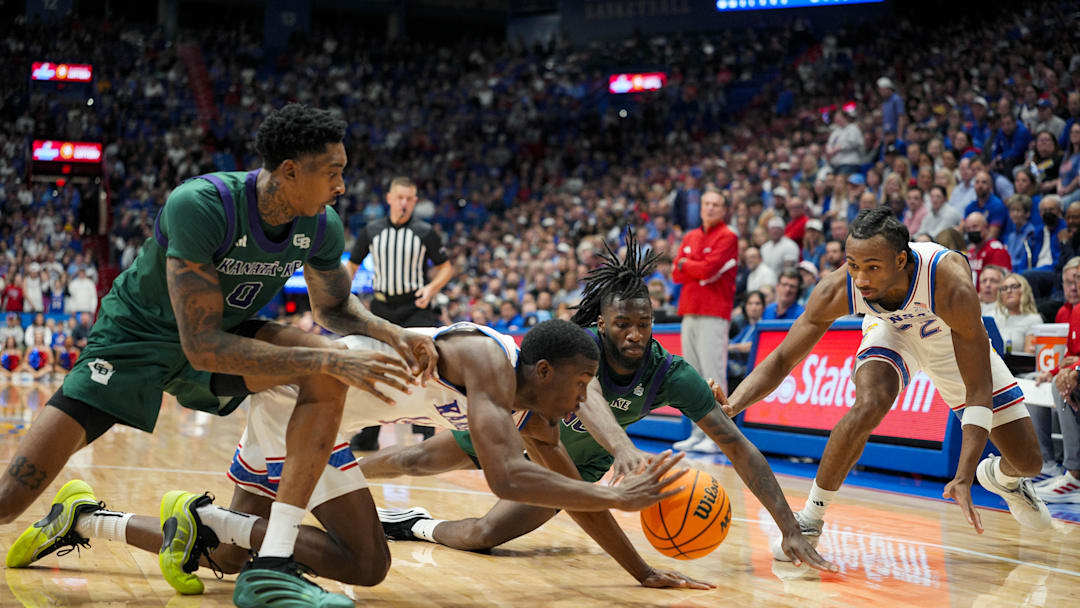 Nov 3, 2025; Lawrence, Kansas, USA; Kansas Jayhawks guard Melvin Council Jr. (14) and guard Darryn Peterson (22) fight for a loose ball against Green Bay Phoenix forward Ramel Bethea (0) and guard C.J. O'Hara (10) during the second half at Allen Fieldhouse. Mandatory Credit: Jay Biggerstaff-Imagn Images