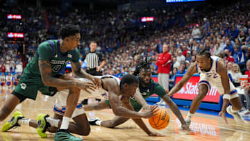 Nov 3, 2025; Lawrence, Kansas, USA; Kansas Jayhawks guard Melvin Council Jr. (14) and guard Darryn Peterson (22) fight for a loose ball against Green Bay Phoenix forward Ramel Bethea (0) and guard C.J. O'Hara (10) during the second half at Allen Fieldhouse. Mandatory Credit: Jay Biggerstaff-Imagn Images