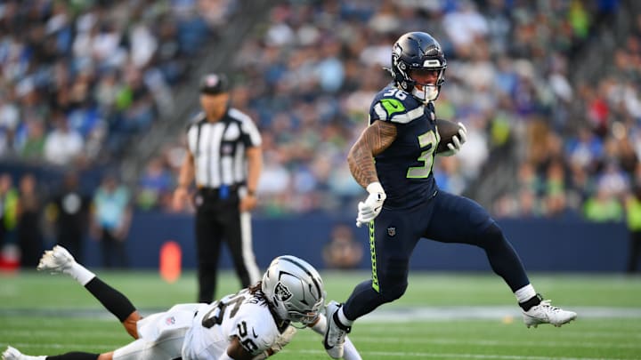 Aug 7, 2025; Seattle, Washington, USA; Seattle Seahawks running back George Holani (36) breaks a tackle by Las Vegas Raiders cornerback Darien Porter (26) during the first half at Lumen Field. Mandatory Credit: Steven Bisig-Imagn Images
