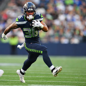 Aug 7, 2025; Seattle, Washington, USA; Seattle Seahawks running back George Holani (36) breaks a tackle by Las Vegas Raiders cornerback Darien Porter (26) during the first half at Lumen Field.