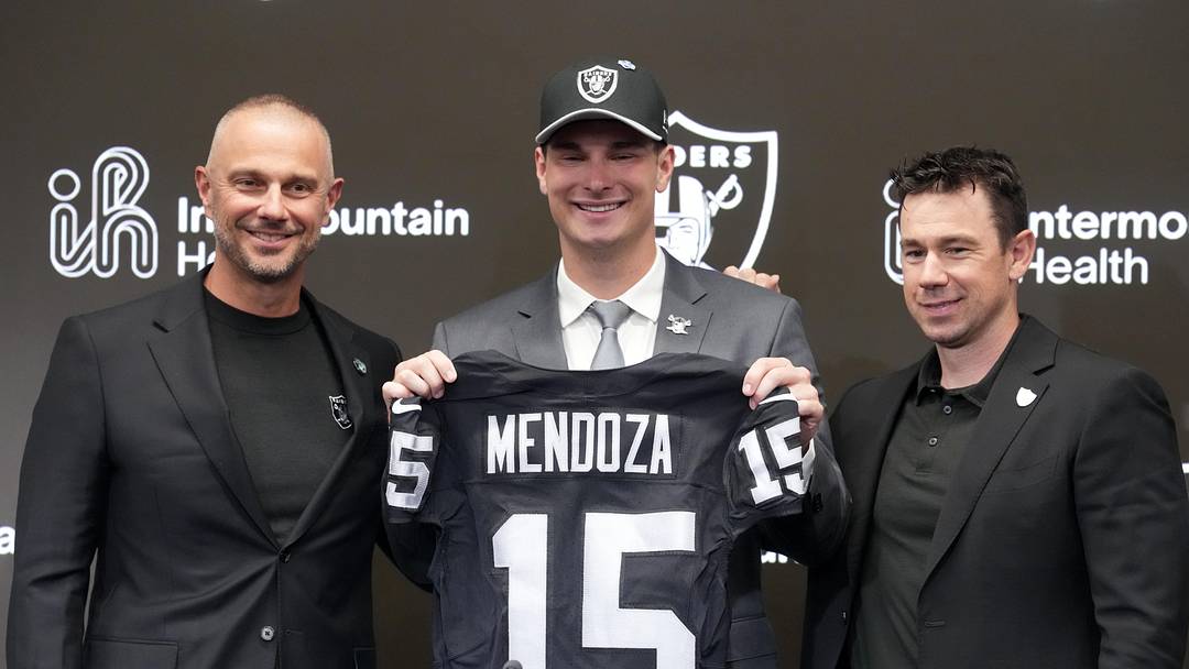 Apr 24, 2026; Henderson, NV, USA; Las Vegas Raiders quarterback Fernando Mendoza (center) poses with jersey at introductory press conference at Intermountain Health Performance Center flanked by general manager John Spytek (left) and head coach Klint Kubiak after being selected as the No. 1 pick in the 2026 NFL Draft. Mandatory Credit: Kirby Lee-Imagn Images
