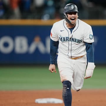 Oct 17, 2025; Seattle, Washington, USA; Seattle Mariners first baseman Josh Naylor (12) reacts after third baseman Eugenio Suarez (not pictured) hits a grand slam against the Toronto Blue Jays in the eighth inning during game five of the ALCS round for the 2025 MLB playoffs at T-Mobile Park. Mandatory Credit: Stephen Brashear-Imagn Images