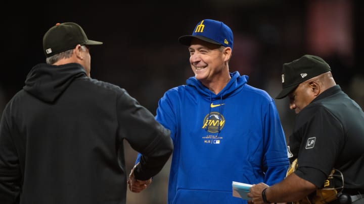 Seattle Mariners manager Dan Wilson, center, greets San Francisco Giants pitching coach Pete Woodworth before a game at T-Mobile Park on Aug 23.