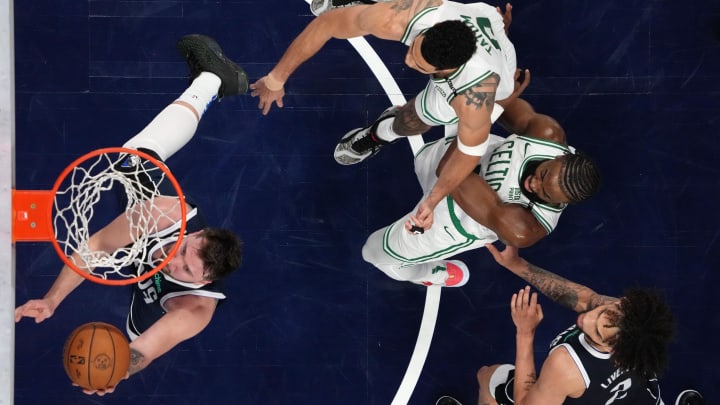 Jun 12, 2024; Dallas, Texas, USA; Dallas Mavericks guard Luka Doncic (77) shoots the ball against Boston Celtics forward Jayson Tatum (0) and guard Jaylen Brown (right) during the third quarter during game three of the 2024 NBA Finals at American Airlines Center. Mandatory Credit: Peter Casey-USA TODAY Sports