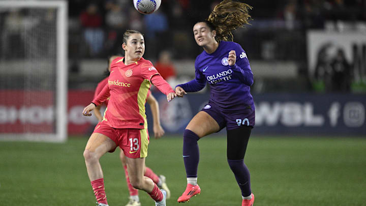 Oct 11, 2024; Portland, Oregon, USA; Orlando Pride midfielder Ally Lemos (30) heads the ball away from Portland Thorns FC midfielder Olivia Moultrie (13) during the second half at Providence Park. Mandatory Credit: Troy Wayrynen-Imagn Images
