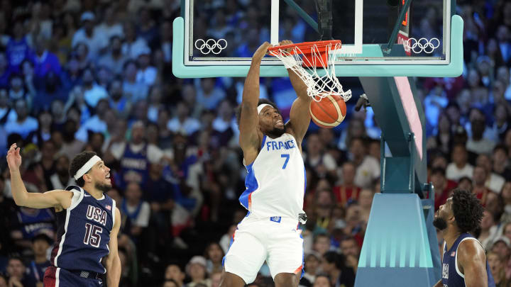 Aug 10, 2024; Paris, France; France power forward Guerschon Yabusele (7) dunks against United States guard Devin Booker (15) and centre Joel Embiid (11) in the first quarter in the men's basketball gold medal game during the Paris 2024 Olympic Summer Games at Accor Arena. Mandatory Credit: Kyle Terada-USA TODAY Sports