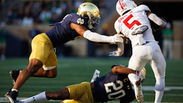 Notre Dame corner back Benjamin Morrison (20) and linebacker Jaiden Ausberry (4) tackle Stanford running back Chris Davis Jr. (5) during a NCAA college football game between Notre Dame and Stanford at Notre Dame Stadium on Saturday, Oct. 12, 2024, in South Bend.