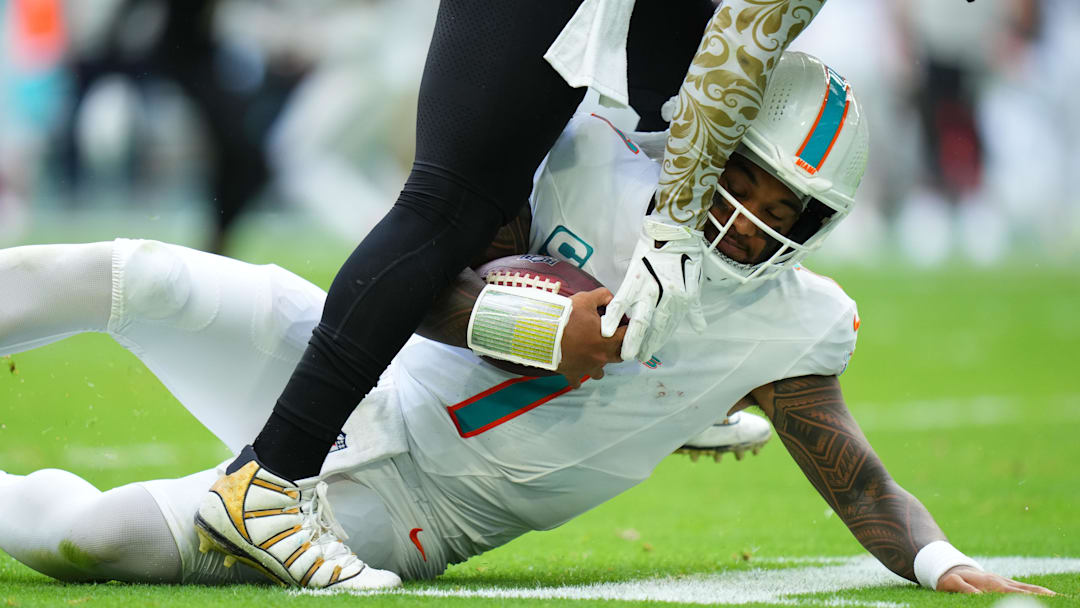 Nov 30, 2025; Miami Gardens, Florida, USA; Miami Dolphins quarterback Tua Tagovailoa (1) slides down against the New Orleans Saints during the second half at Hard Rock Stadium. 