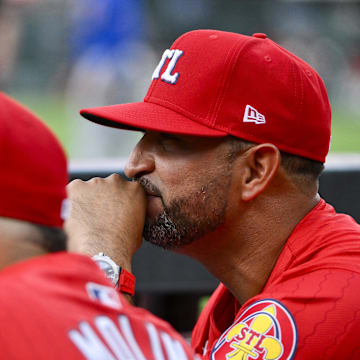 Aug 8, 2025; St. Louis, Missouri, USA;  St. Louis Cardinals manager Oliver Marmol (37) and guest coach Yadier Molina (4) look on from the dugout before a game against the Chicago Cubs at Busch Stadium. Mandatory Credit: Jeff Curry-Imagn Images