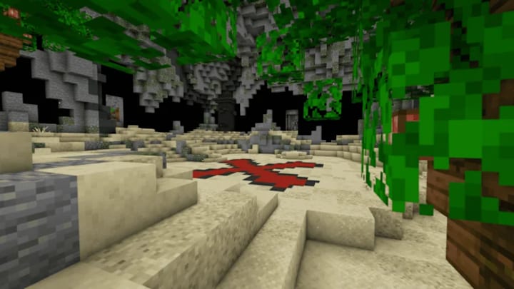 An X on the ground of a sandy cave chamber from the Vault Hunters Minecraft mod.