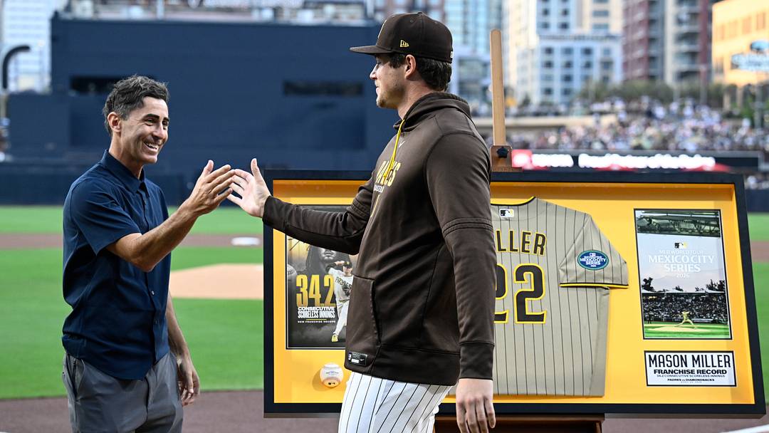 May 7, 2026; San Diego, California, USA; San Diego Padres pitcher Mason Miller (22) is congratulated by general manager A.J. Preller during a ceremony honoring Miller for setting a franchise record for the most consecutive scoreless innings before a game against the St. Louis Cardinals at Petco Park. Mandatory Credit: Denis Poroy-Imagn Images