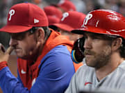 Philadelphia Phillies manager Rob Thomson (left) and first baseman Bryce Harper (right) look on from the dugout during a game against the Arizona Diamondbacks in June of 2023. 