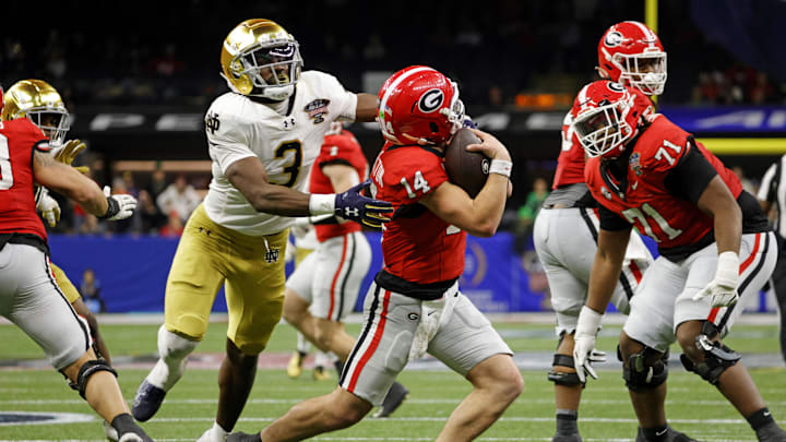 Jan 2, 2025; New Orleans, LA, USA; Georgia Bulldogs quarterback Gunner Stockton (14) runs with the ball during the second half against Notre Dame Fighting Irish running back Gi'Bran Payne (3) at Caesars Superdome. Jan 2, 2025; New Orleans, LA, USA; Georgia Bulldogs quarterback Gunner Stockton (14) runs with the ball during the second half against Notre Dame Fighting Irish running back Gi'Bran Payne (3) at Caesars Superdome.