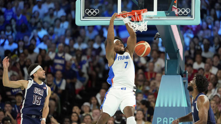 Aug 10, 2024; Paris, France; France power forward Guerschon Yabusele (7) dunks against United States guard Devin Booker (15) and centre Joel Embiid (11) in the first quarter in the men's basketball gold medal game during the Paris 2024 Olympic Summer Games at Accor Arena. Mandatory Credit: Kyle Terada-USA TODAY Sports