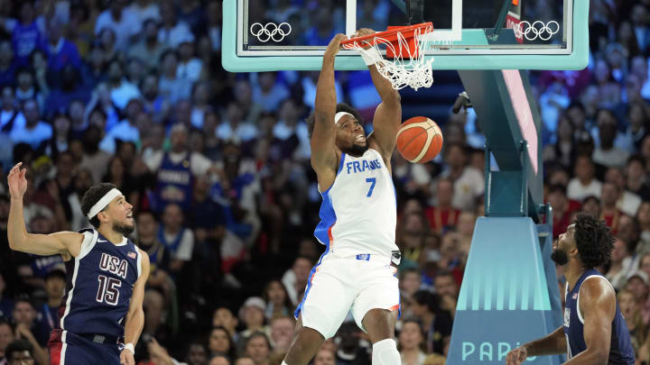 Aug 10, 2024; Paris, France; France power forward Guerschon Yabusele (7) dunks against United States guard Devin Booker (15) and centre Joel Embiid (11) in the first quarter in the men's basketball gold medal game during the Paris 2024 Olympic Summer Games at Accor Arena. Mandatory Credit: Kyle Terada-USA TODAY Sports