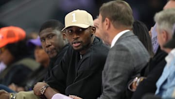 Golden State Warriors forward Jonathan Kuminga talks with owner Joe Lacob during a WNBA game.