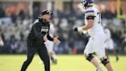 Nov 2, 2024; West Lafayette, Indiana, USA;  Northwestern Wildcats head coach David Braun reacts to a touchdown in front of Northwestern Wildcats offensive lineman Deuce McGuire (73) during the second quarter at Ross-Ade Stadium. Mandatory Credit: Marc Lebryk-Imagn Images