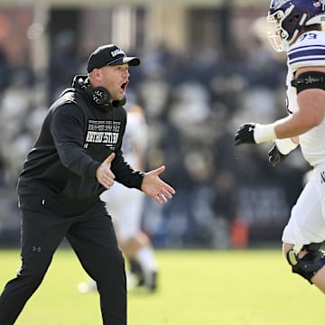 Nov 2, 2024; West Lafayette, Indiana, USA;  Northwestern Wildcats head coach David Braun reacts to a touchdown in front of Northwestern Wildcats offensive lineman Deuce McGuire (73) during the second quarter at Ross-Ade Stadium. Mandatory Credit: Marc Lebryk-Imagn Images