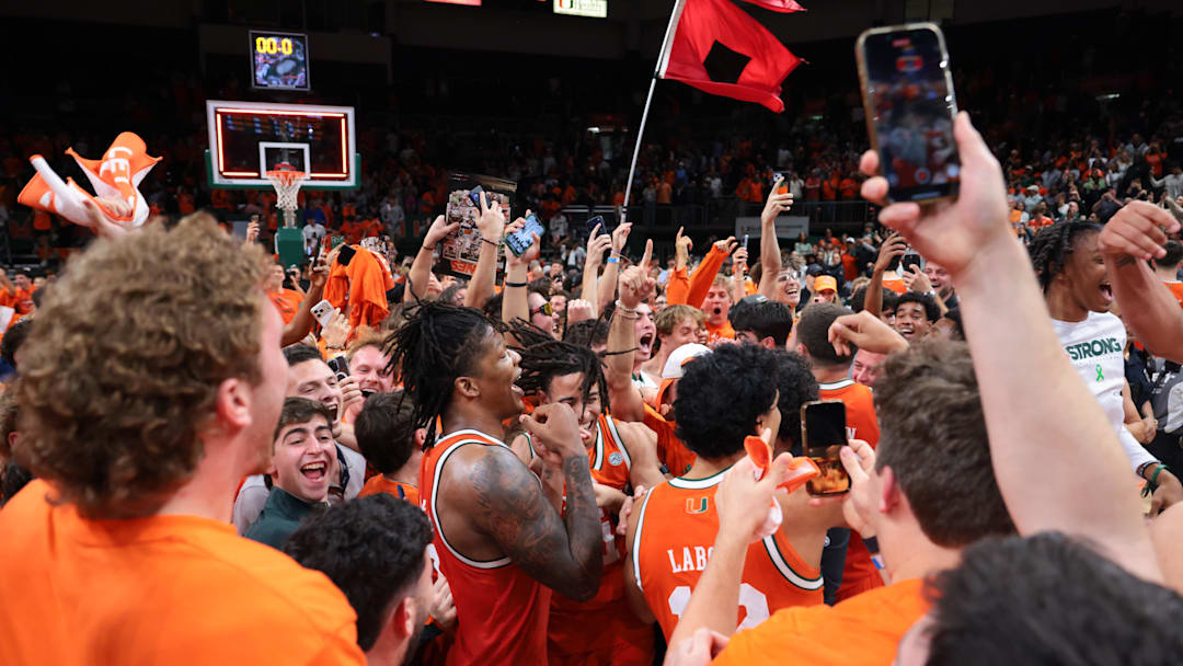 Feb 10, 2026; Coral Gables, Florida, USA; Miami Hurricanes forward Shelton Henderson (7) celebrates with teammates as fans storm the court after the game against the North Carolina Tar Heels at Watsco Center. Mandatory Credit: Sam Navarro-Imagn Images