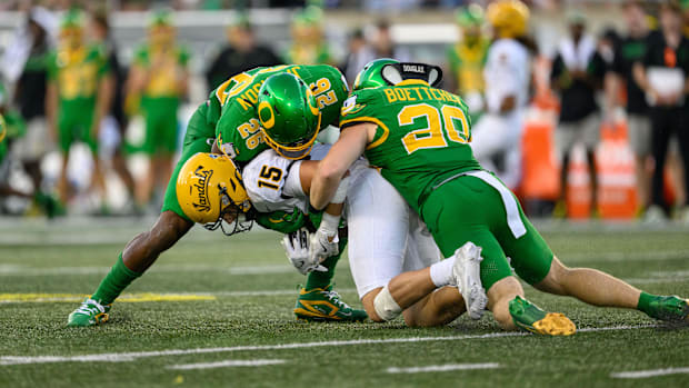   Oregon Ducks linebacker Bryce Boettcher (28) and linebacker Devon Jackson (26) tackle Idaho Vandals wide receiver Mark Hamp