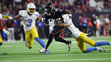 Jan 11, 2025; Houston, Texas, USA; Houston Texans wide receiver Diontae Johnson (82) runs the ball after a reception against Los Angeles Chargers defensive back Deane Leonard (33) and safety Derwin Jarnes Jr. (3) during the third quarter in an AFC wild card game at NRG Stadium.